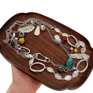 Vintage boho long necklace with ceramic beads and engraved silver metal discs on wood tray