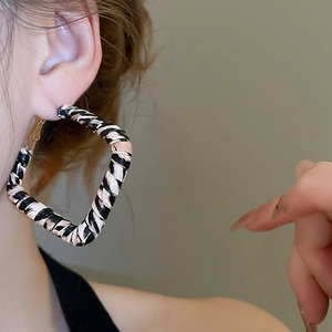 Gros plan de boucles d'oreilles créoles carrées à motif léopard portées par un mannequin