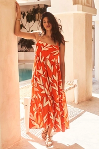 Detail of summer tiered maxi dress with orange leaf print and delicate spaghetti straps