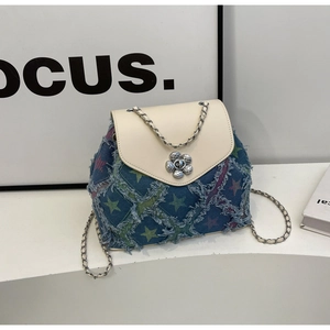 Close-up of star pattern denim backpack with metal flower buckle and chain strap detail