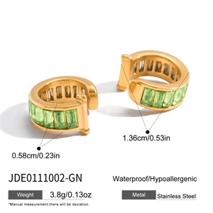 Detail view of gold stainless steel C-shaped earrings with green rectangular gemstones