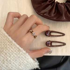 Retro zircon open ring in gold metal with brown and blue resin circles on model hand