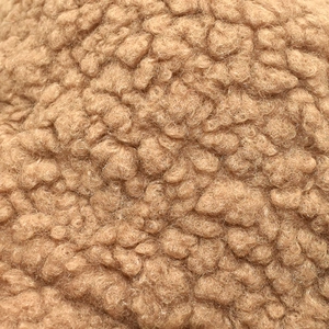 Détail macro de la texture douce et pelucheuse en polaire teddy de couleur marron