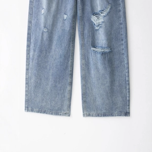 Jeans dritti azzurri lavati con dettagli strappati ed effetto usurato sulle ginocchia