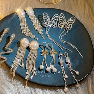 Detailed collection of s925 silver needle zircon earrings with pearls on a black tray