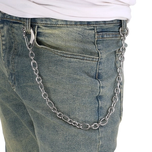Detail of silver O-chain trouser link with skull clasp on light blue denim jeans