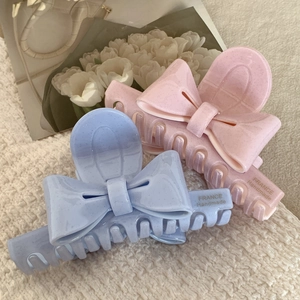 Pinces à cheveux nœud en acétate rose et bleu sur un fond texturé doux élégant