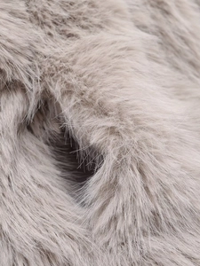 Close-up of premium taupe faux fox fur fabric showing soft plush texture and high density