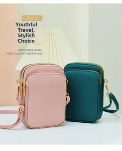 Detail view of pink and green nylon crossbody phone bags with triple zipper layers