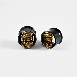 Detail of black hollow ear tunnels featuring a vintage golden Santa skull inlay
