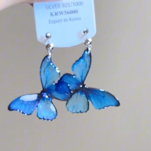 Détail de boucles d'oreilles papillon dégradé bleu avec crochets en argent 925