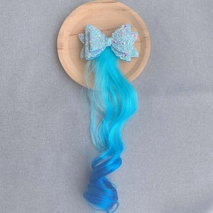 Detail of blue sequin bow hair clip with long gradient curly synthetic hair extension