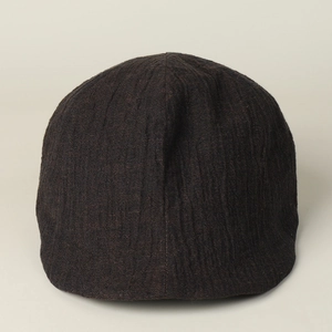 Detail of dark brown linen newsboy cap featuring vertical pleated fabric and retro style