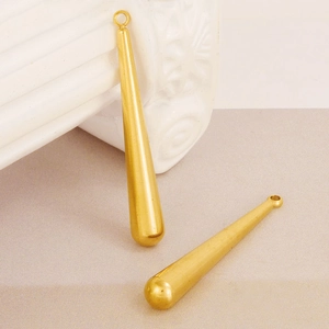 Polished gold teardrop pendants for DIY jewelry making on a minimalist display base