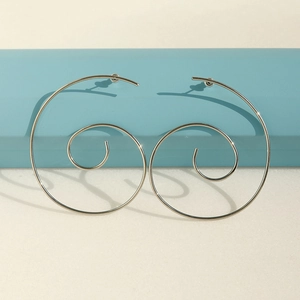 Minimalist silver spiral earrings set on stone surface with artistic swirl design