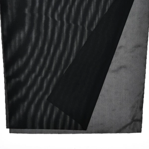 Detail of black sheer mesh fabric texture with pleated translucent layers on a dress