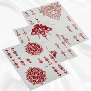 Three sheets of red mandala henna lace tattoo stickers displayed on white silk fabric