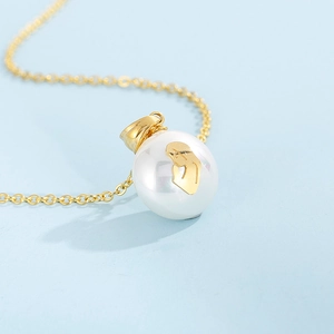Close-up of golden stainless steel necklace with a pearl pendant featuring a prayer figure