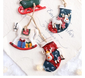 Flat lay of resin Christmas ornaments with sleigh and reindeer motifs on art paper