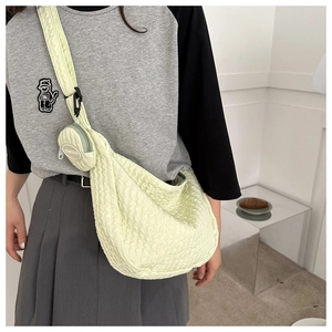 Close-up of a pale yellow bubble texture crossbody bag with a round coin purse accessory
