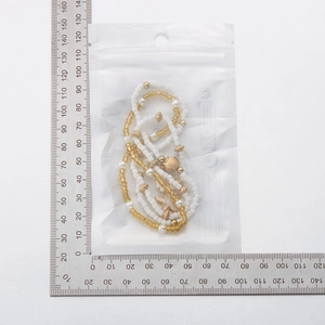Detail view of Bohemian seed bead necklace with starfish and shell charms next to a ruler
