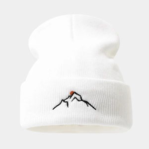 Gros plan du bonnet blanc en maille côtelée avec broderie de montagne noire et soleil rouge