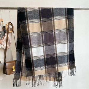 Detail of plaid cashmere scarf with tassels, neutral check pattern on metal rack