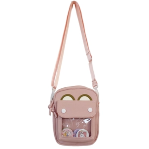 Close-up of pink crossbody bag with a bear badge inside a transparent window