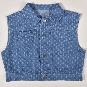 Detail shot of distressed blue denim vest featuring frayed edges and silver metal buttons