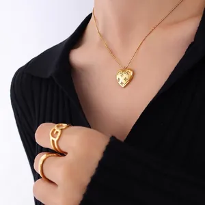 Elegant gold heart pendant necklace with star motif and hollow geometric ring on model