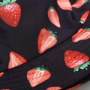 Detail shot of black bucket hat with red strawberry prints and high-density stitching