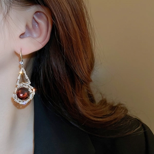 Détail de boucles d'oreilles vintage avec cristal rouge et zircon sur le modèle
