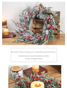 Detail of a Christmas wreath with snow-dusted pine needles, red berries, and natural cones