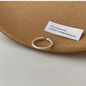 Detailed view of silver minimalist twisted rope open ring with polished metal texture