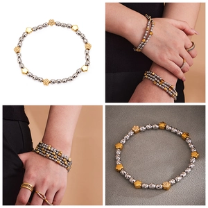 Detail of beaded flower bracelet featuring silver and gold steel beads with zircon charms