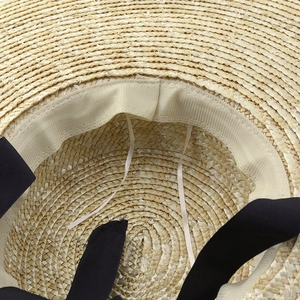 Hepburn style wide brim straw sun hat with black ribbon and interior adjustable strap