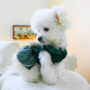 Detailed view of the dark green satin pet dress with mesh skirt and bow on a small dog