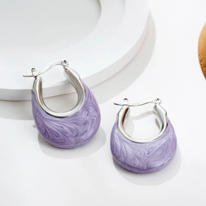 Detailed macro of U-shaped silver earrings with purple marble enamel and click-on closure