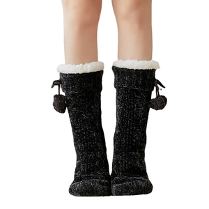 Thick black knitted floor socks with white faux fur trim and pom-poms for winter warmth