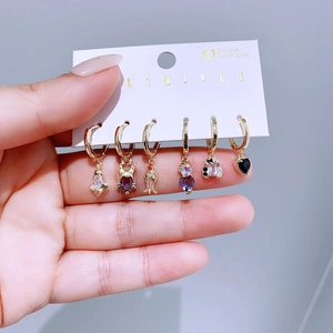 Detail of 6-piece gold hoop earring set with colorful heart and teardrop zircon pendants
