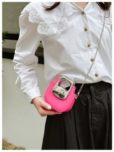 Detail of mini rose red crossbody bag with silver metal handle and chain strap