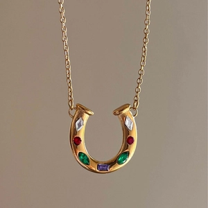 Gold horseshoe necklace featuring colorful rainbow gemstones on a delicate chain link