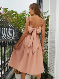 Detail of a dusty pink bohemian maxi dress featuring an elegant backless bow design