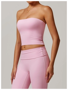 Détail d'un haut bustier rose clair et d'un pantalon de yoga en tissu élastique mat