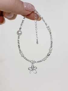 Close-up of S925 silver flower charm bracelet with freshwater pearls and adjustable chain