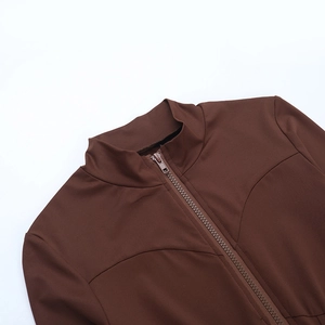 Detail of front zipper closure and stand-up collar on a slim brown jumpsuit
