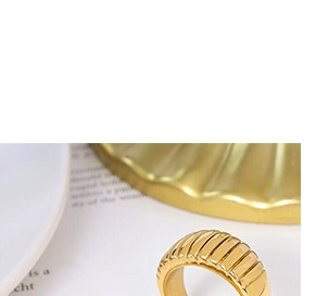 Macro shot of 18k gold plated stainless steel croissant ring on a wave tray