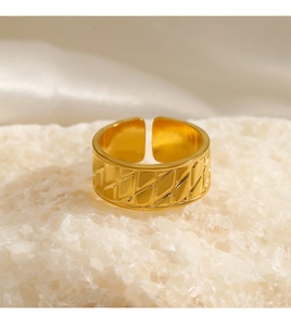 Nahaufnahme des goldenen geometrischen Rings mit Rautenmuster auf weißem Kristall