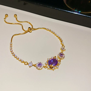 Detail of adjustable 18k gold plated bracelet with oval purple and clear zircon stones