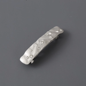 Silver metallic rhinestone hair clip with irregular wave design and hammered texture